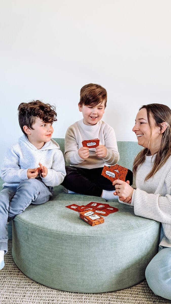 Mum and children playing Really Good Conversations on the sofa